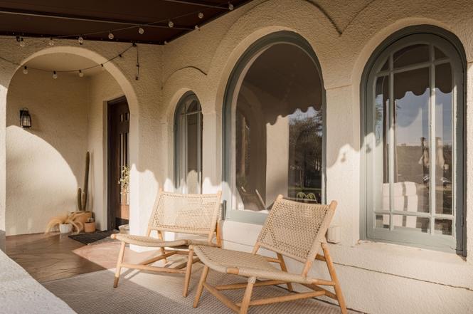 Dramatic arched black steel entry door with white stucco — Arizona Spanish Revival